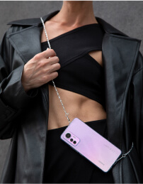 A girl in an overcoat with a phone on a chain.